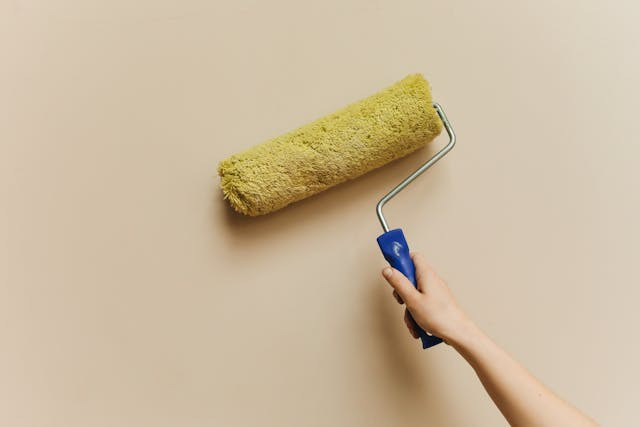 yellow-paint-roller-on-wall