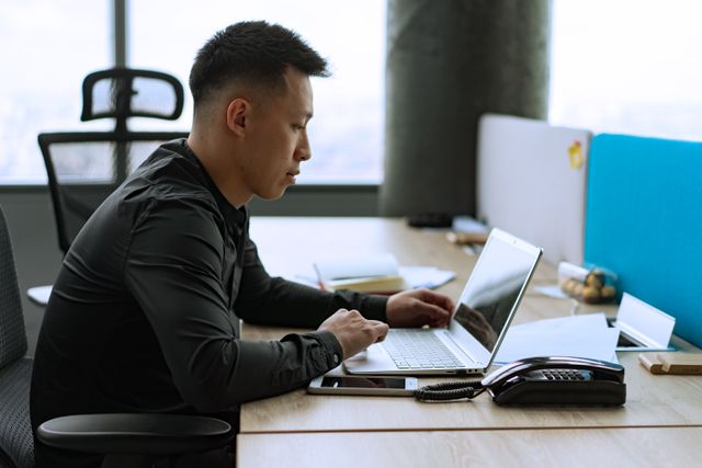 person sitting at a desk using a laptop